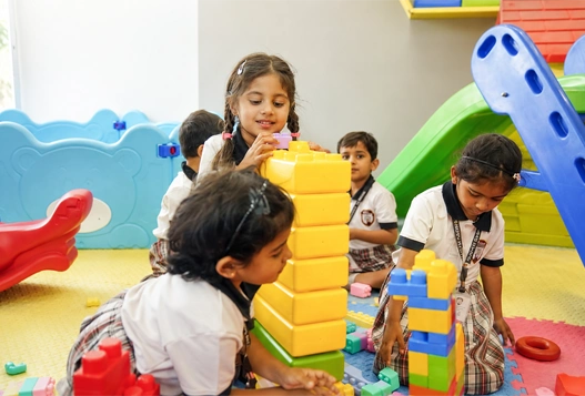 Early years 1 kids exploring colors, shapes and sounds through play with building blocks.