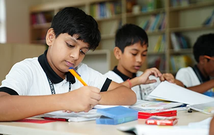 Primary school students engaged in skill development and creative learning activities in a classroom.