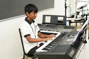 Student practicing musical instruments and vocal skills in a dedicated practice room.