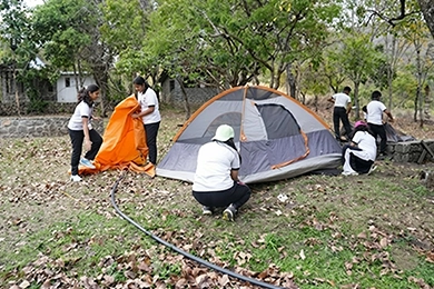 Student clubs supporting higher secondary learning and growth pitching a tent outdoors.