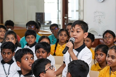 Public speaking activities for primary school students in Vanagaram speaking into mic.