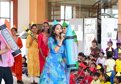 Teachers and children participating in a creative arts event with colorful themed activities